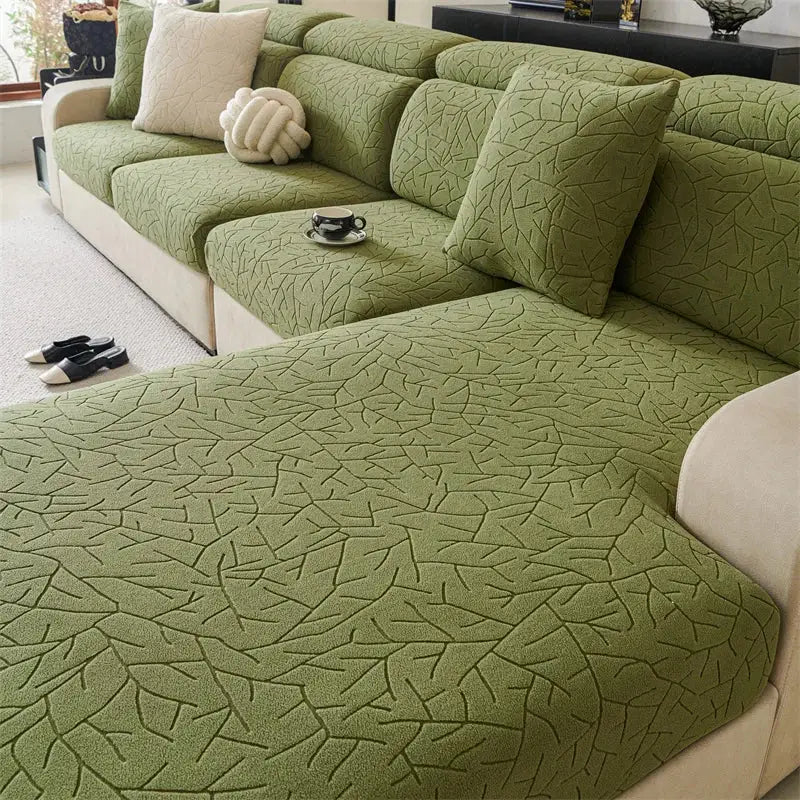 Olive green textured quilted sofa cover with elastic fit and leaf pattern for living room use