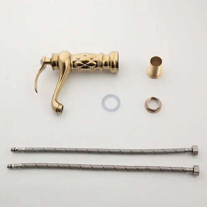Gold-colored decorbites golden plated bathroom basin faucet with ornate diamond engraving and braided metal hoses