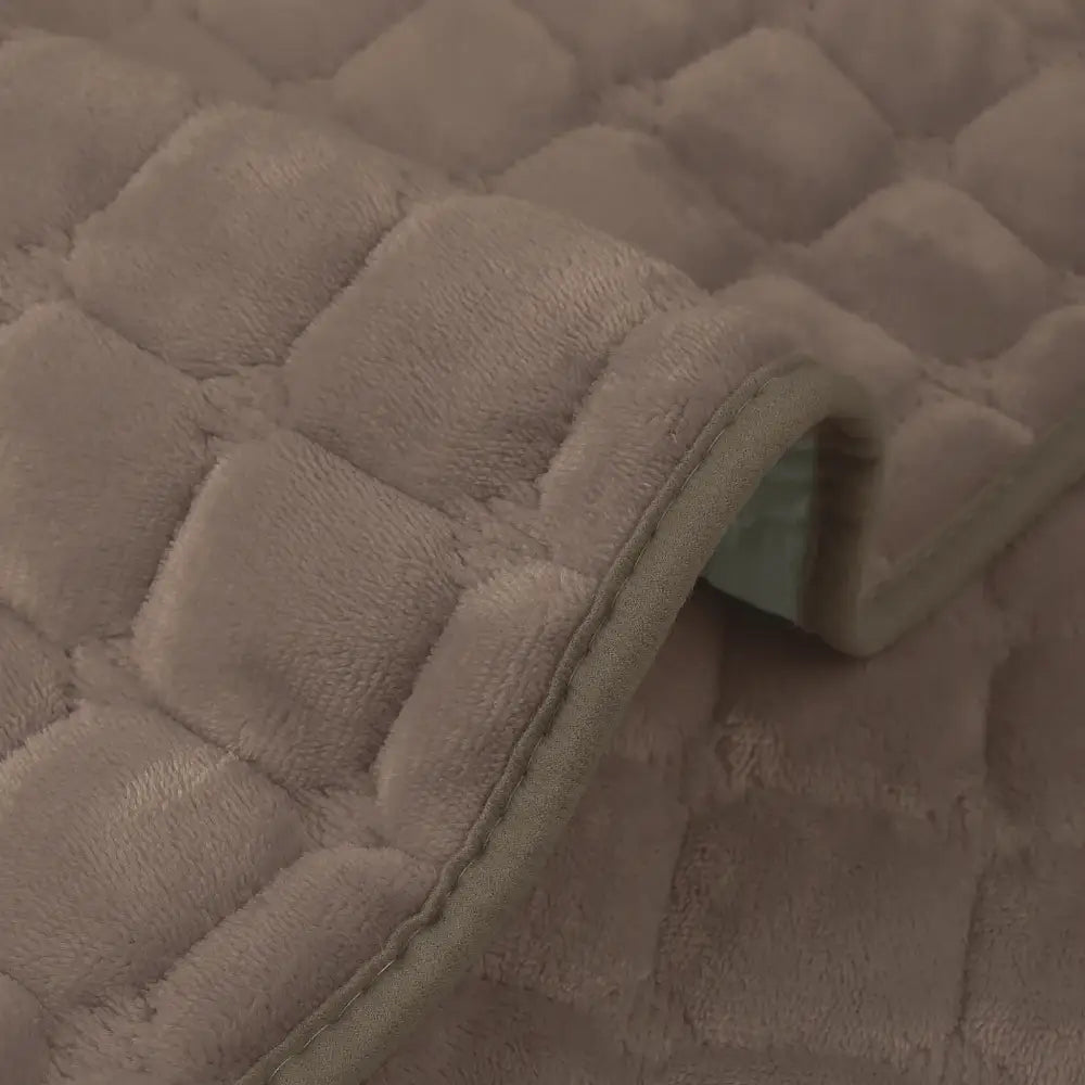 Beige quilted plush sofa cover with soft fuzzy texture and stitched edge for non slip living room use