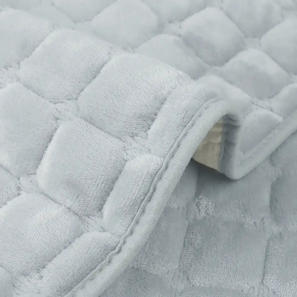 Soft light gray quilted plush sofa cover with stitched square patterns designed as a non slip living room slipcover