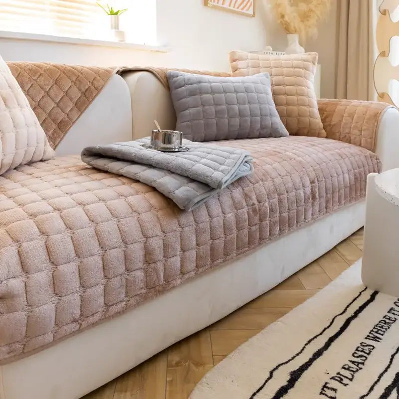 Beige quilted plush sofa cover set with soft textured surface and matching pillows for living room use