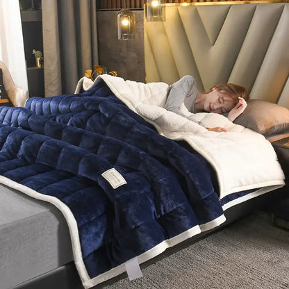A plush navy blue and white quilted bed blanket with cozy coral fleece fabric for comfortable bedroom use