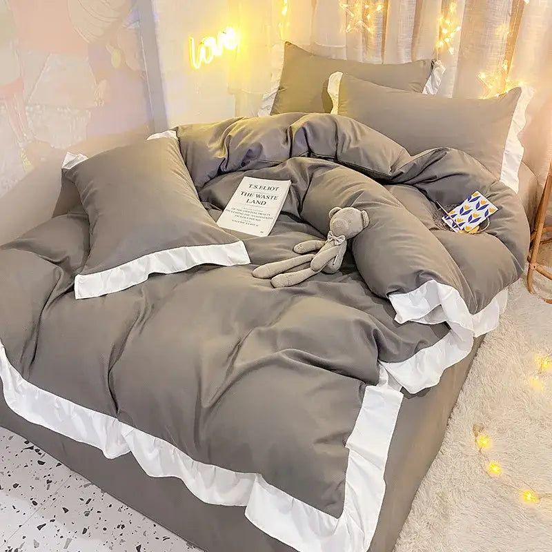 Gray ruffled duvet cover set with white trim featuring quilted light blue and white ruffle design for bedroom bedding