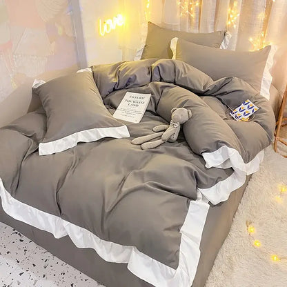 Gray ruffled duvet cover set with white trim featuring quilted light blue and white ruffle design for bedroom bedding
