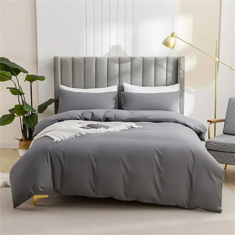 Gray tufted velvet bed with matching gray duvet and white pillows featuring a quilted tan duvet cover set for soft bedding