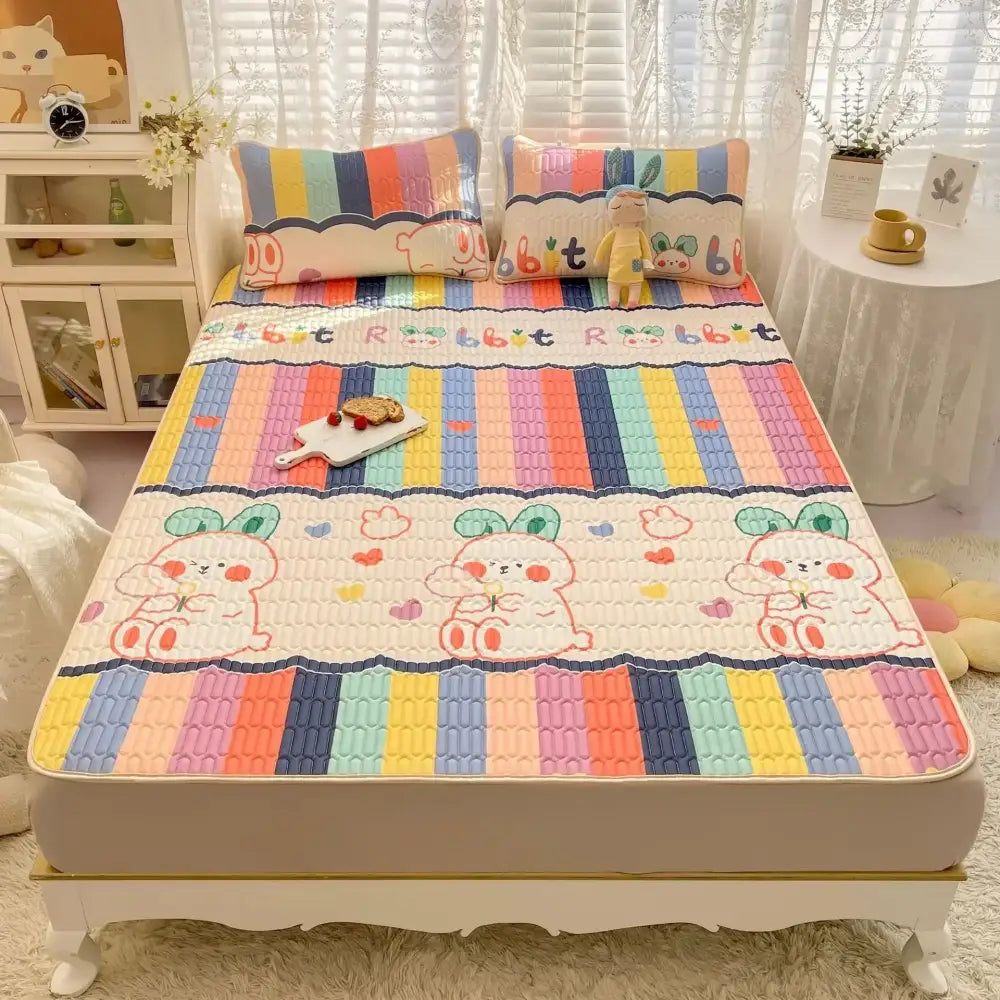 Rainbow striped quilted cooling mattress pad with decorbites cartoon print featuring rabbits in cream mattress set