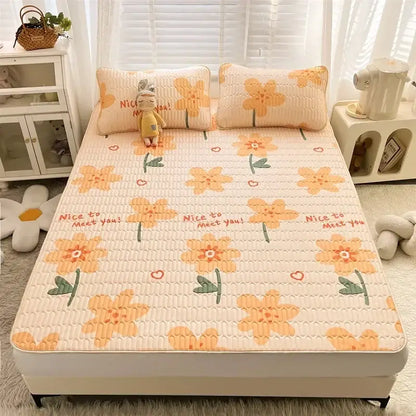 Cream-colored quilted bed pad with orange floral patterns and nice to meet you text in decorbites cartoon print mattress set