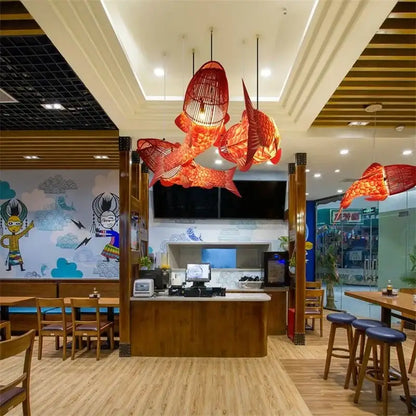 Red bamboo fish pendant light with woven wireframe design hanging as decorbites bamboo fish pendant in living room