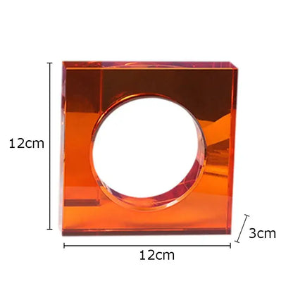A translucent orange acrylic square centerpiece with circular cutout in a red and blue crystal arch glass sculpture
