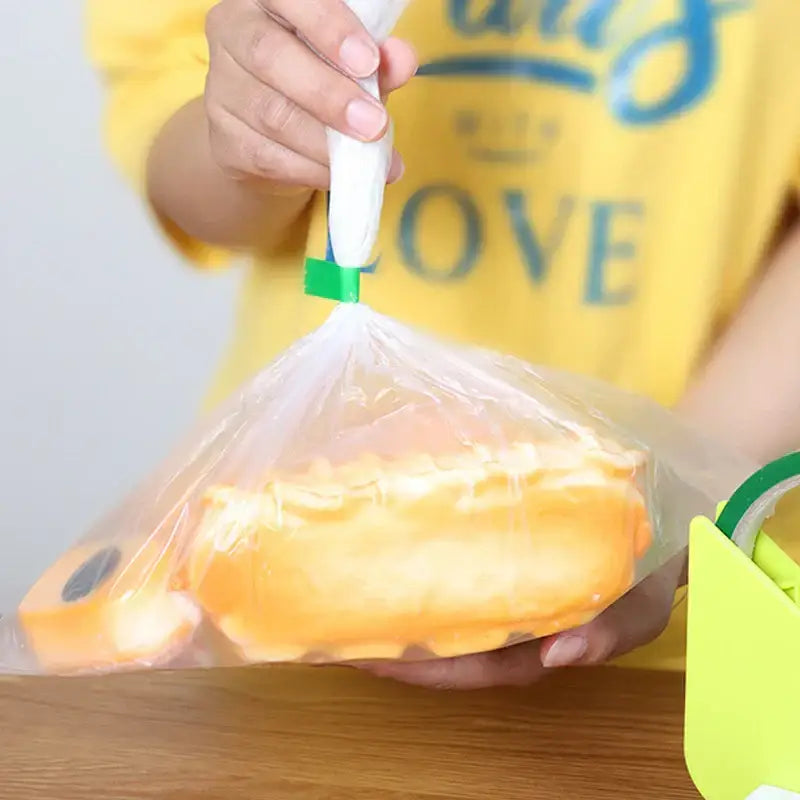 A clear plastic bag sealed with green clip and white nozzle using red and green bag seal tape for kitchen freshness