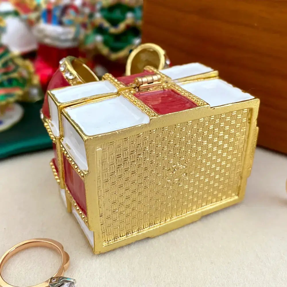 A gold-toned woven jewelry trinket box with red and white enamel bow accents for bedroom gift storage