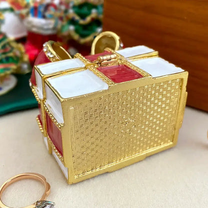 A gold-toned woven jewelry trinket box with red and white enamel bow accents for bedroom gift storage