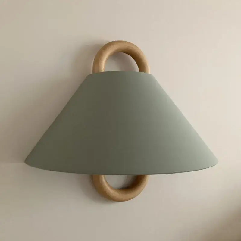 Minimalist beech wood wall lamp with matte sage green conical shade and natural wood rings for bedroom sconce use