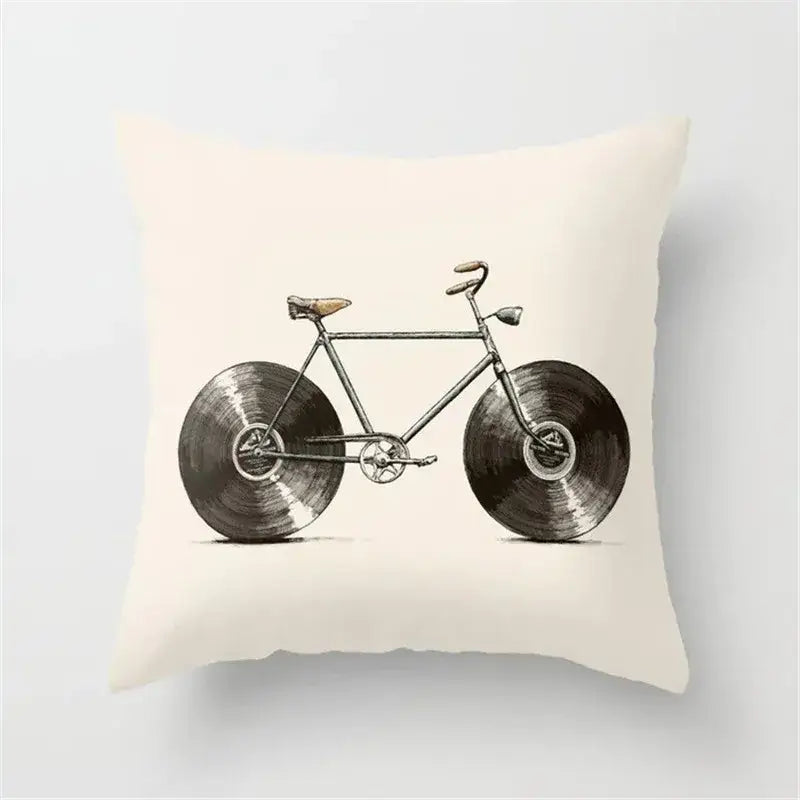 Cream-colored cushion cover featuring vintage-style bicycle illustration with black camera print vinyl record wheels for decor