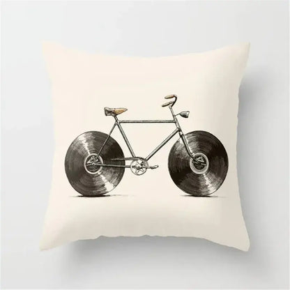 Cream-colored cushion cover featuring vintage-style bicycle illustration with black camera print vinyl record wheels for decor