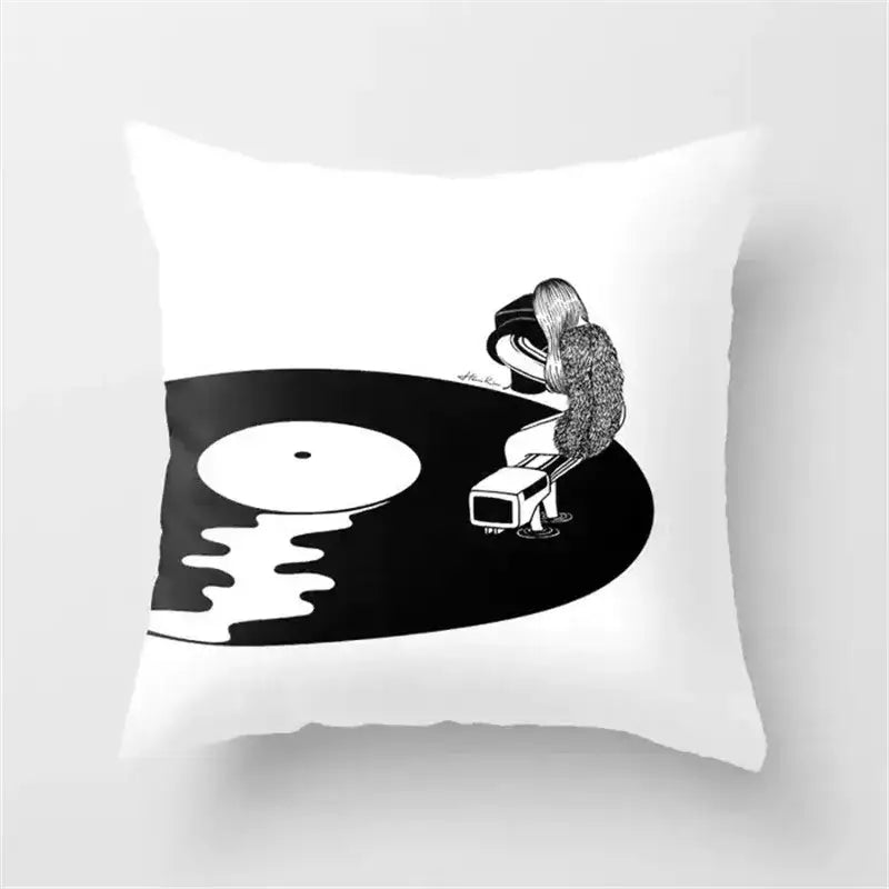White cushion cover with black camera print featuring a person sitting on a vinyl record holding a tonearm for living room decor