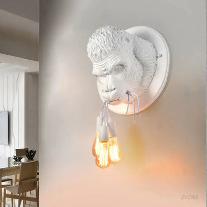 Retro black gorilla resin wall sconce with white monkey head and three exposed filament bulbs decorbites gorilla resin wall