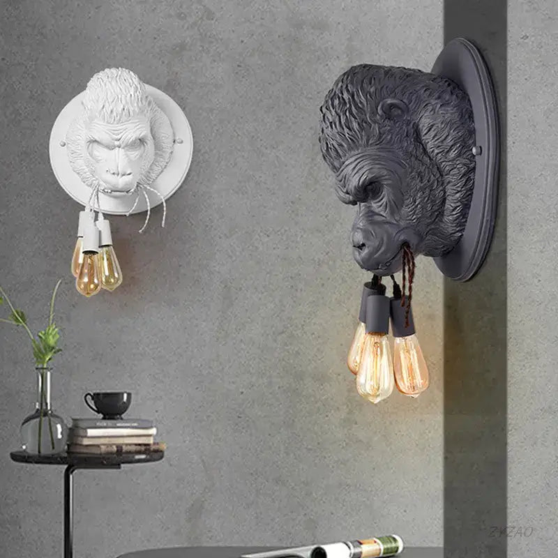 Two wall sconce monkey heads in white and dark gray resin with three filament bulbs by decorbites gorilla resin wall design