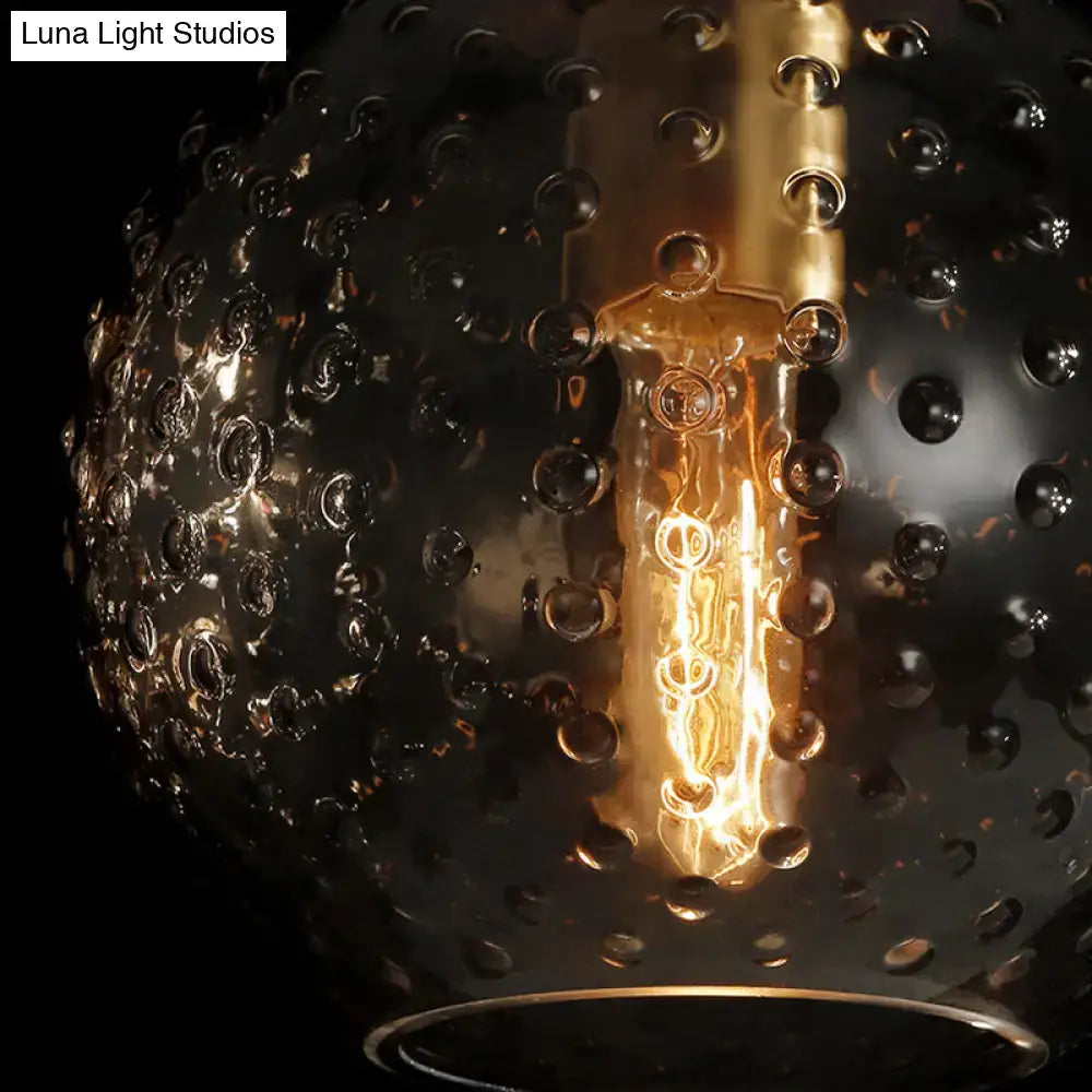 Retro blue glass globe wall lamp with textured dark glass pendant and golden filament bulb in pink yellow blue tones