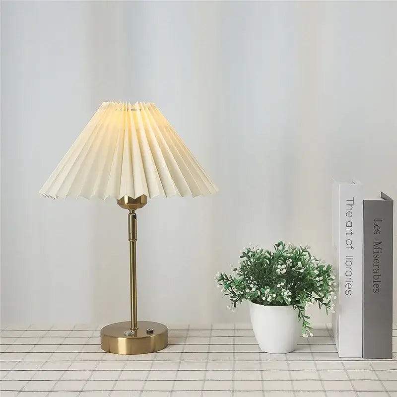 A cream-colored pleated table lamp with a brass-finished base from decorbites adjustable pleated collection