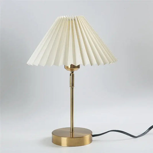 Cream-colored pleated lampshade on a slender brass finish adjustable pleated table lamp for bedroom decorbites lighting