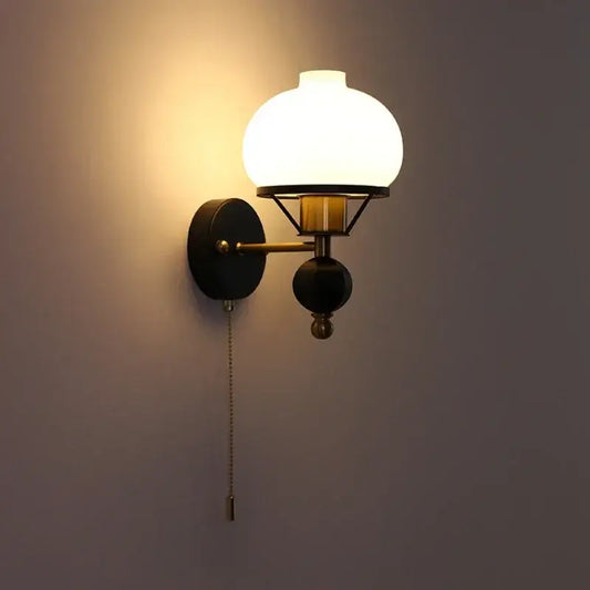 Warm-toned globe glass wall lamp with brass and black metal frame perfect for decorbites french wall lamp settings