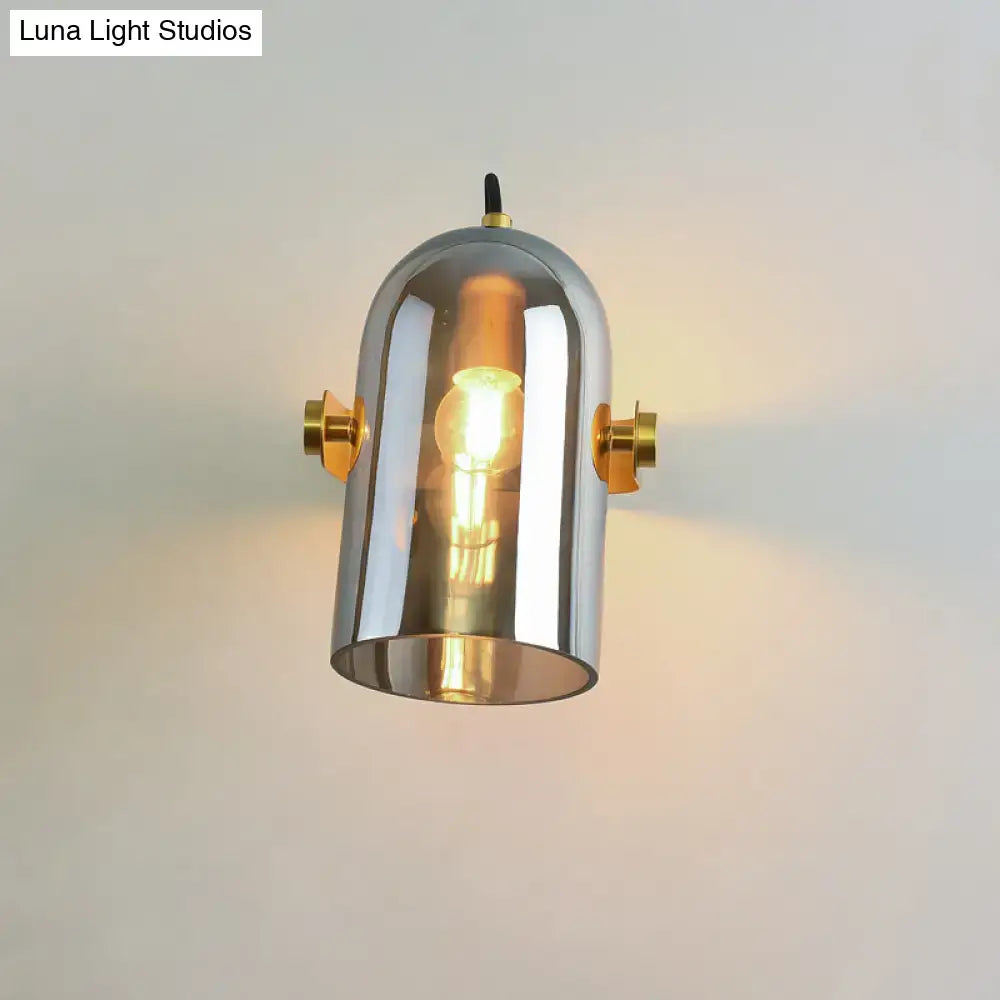 Chrome finished cylindrical pendant light with brass accents and filament bulb complementing retro cloche sconce light