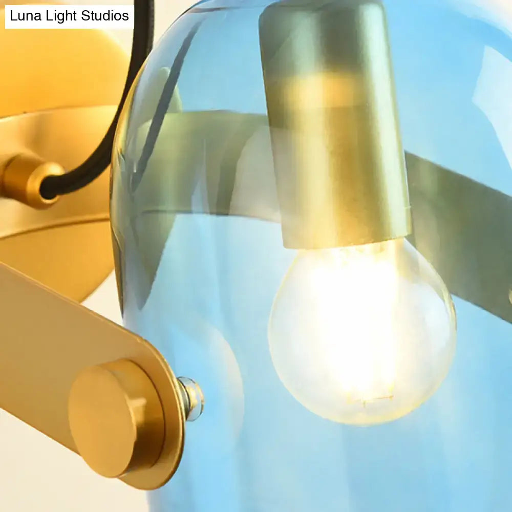 Retro brass cloche sconce light with blue glass shade, brass accents, and exposed bulb for bedroom lighting