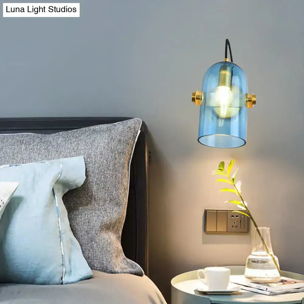 Retro brass cloche sconce light with blue glass and gold-toned hardware for bedroom featuring a smoke gray shade
