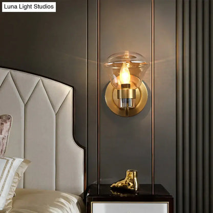 Gold-toned retro brass light fixture with smoke gray amber glass dome and exposed filament bulb for bedroom sconce