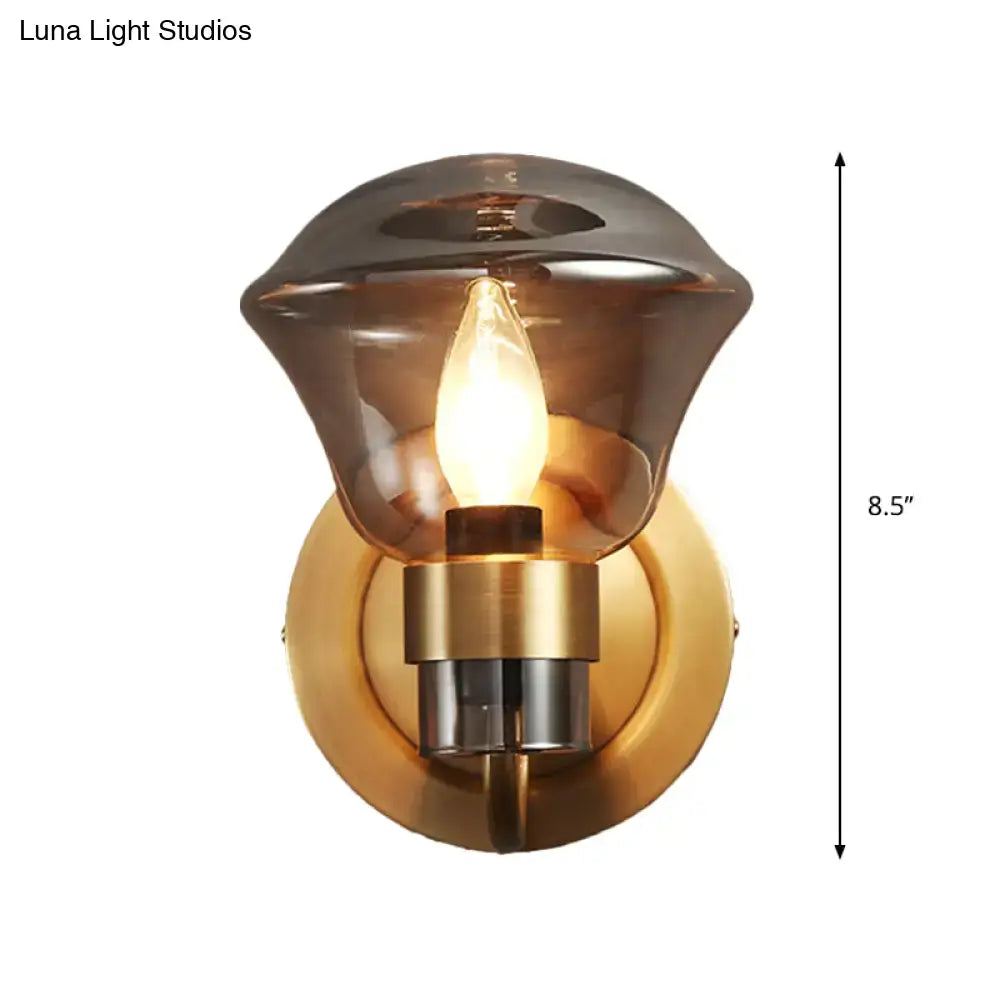 Retro brass smoke gray and amber glass wall light fixture with warm amber-tinted glass and brass chrome base illuminated bulb