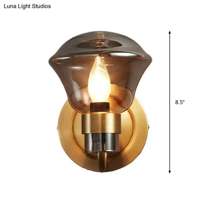 Retro brass smoke gray and amber glass wall light fixture with warm amber-tinted glass and brass chrome base illuminated bulb