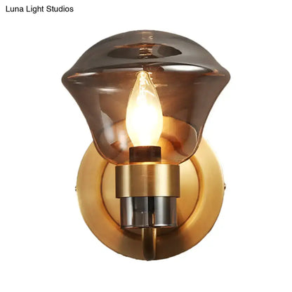 Retro brass smoke gray amber glass light fixture featuring a warm-toned amber glass sconce with brass base and exposed bulb
