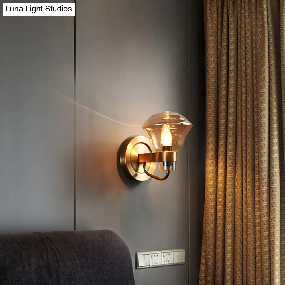 Brass-finished bedroom wall light fixture with faceted amber glass shade and smoke gray amber accents