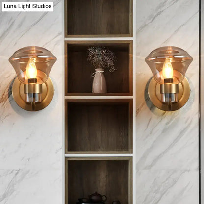 Warm-toned amber glass light fixture with brass-finished base and cylindrical stem for bedroom smoke gray amber sconce
