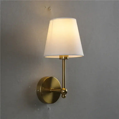 Brass-finished wall lamp with gold led retro design and tapered white fabric shade for bedroom sconce lighting