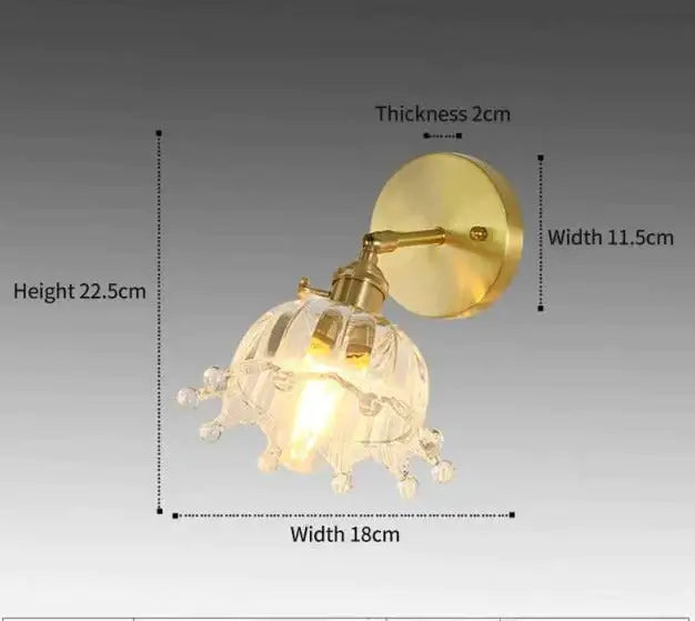 Brass wall sconce with a retro copper finish and clear faceted flower-shaped glass shade for bedroom lighting