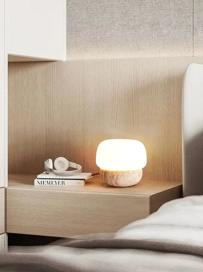 A decorbites cream mushroom table lamp with a smooth white glass top and textured stone base for bedroom decor