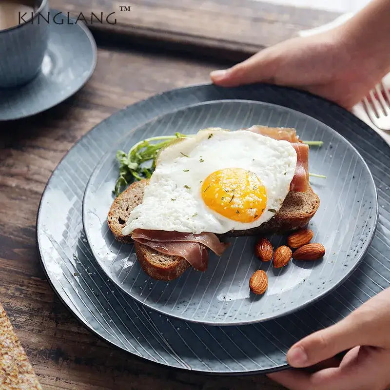Dark gray ceramic dinner plate with subtle vertical ridges and speckled finish from decorbites ceramic dinner collection