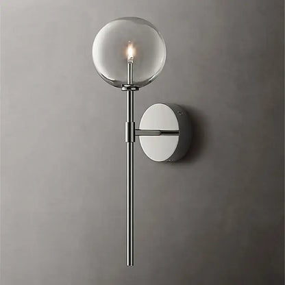 Modern wall sconce with a clear glass ball globe, sleek chrome stem, and circular backplate for living room lighting