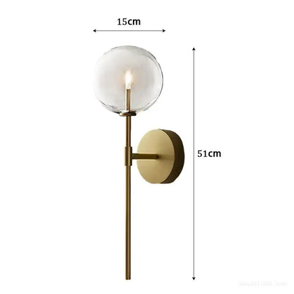 Retro gold wall sconce with clear glass ball globe and slender rod for elegant living room lighting