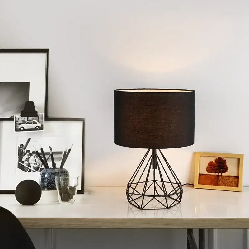 Black geometric table lamp with metal base and textured fabric shade for study room lighting