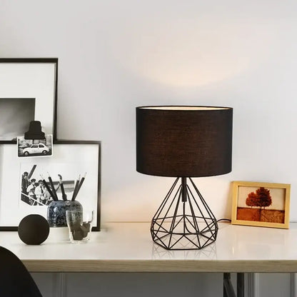 Black geometric table lamp with metal base and textured fabric shade for study room lighting