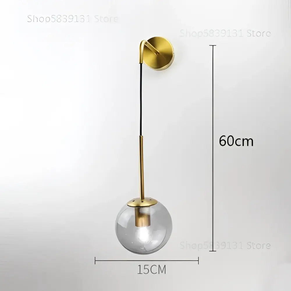 Gold-toned retro wall lamp with clear glass ball and slender metallic stem for bedroom decorbites glass ball wall decor
