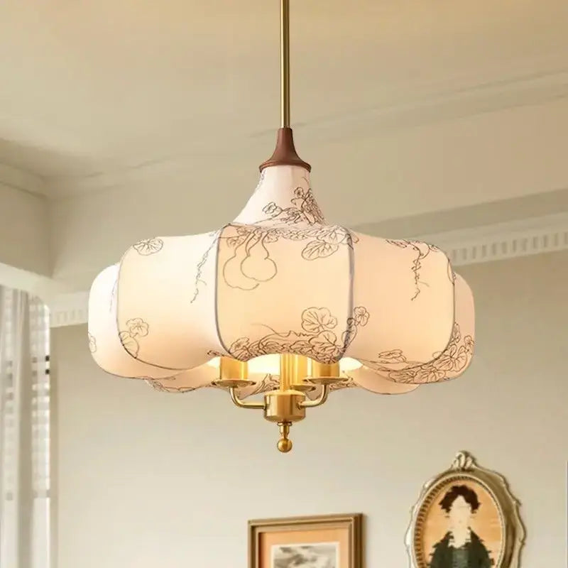 Off-white lantern-style pendant lights with intricate black floral embroidery and brass frame for bedroom decorbites gold lustre