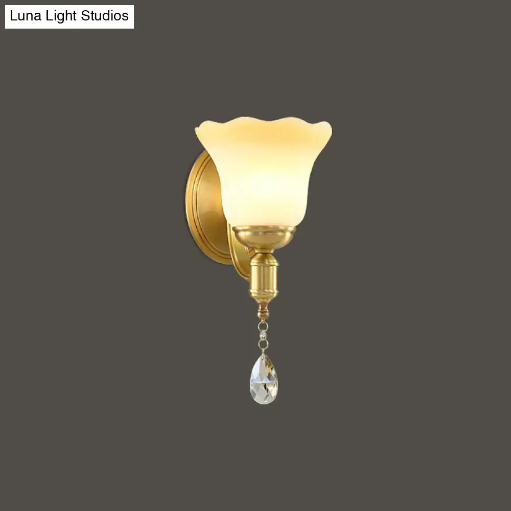 Gold-toned retro wall lamp with blossom opaque glass shade and dangling crystal teardrop for bedroom sconce lighting