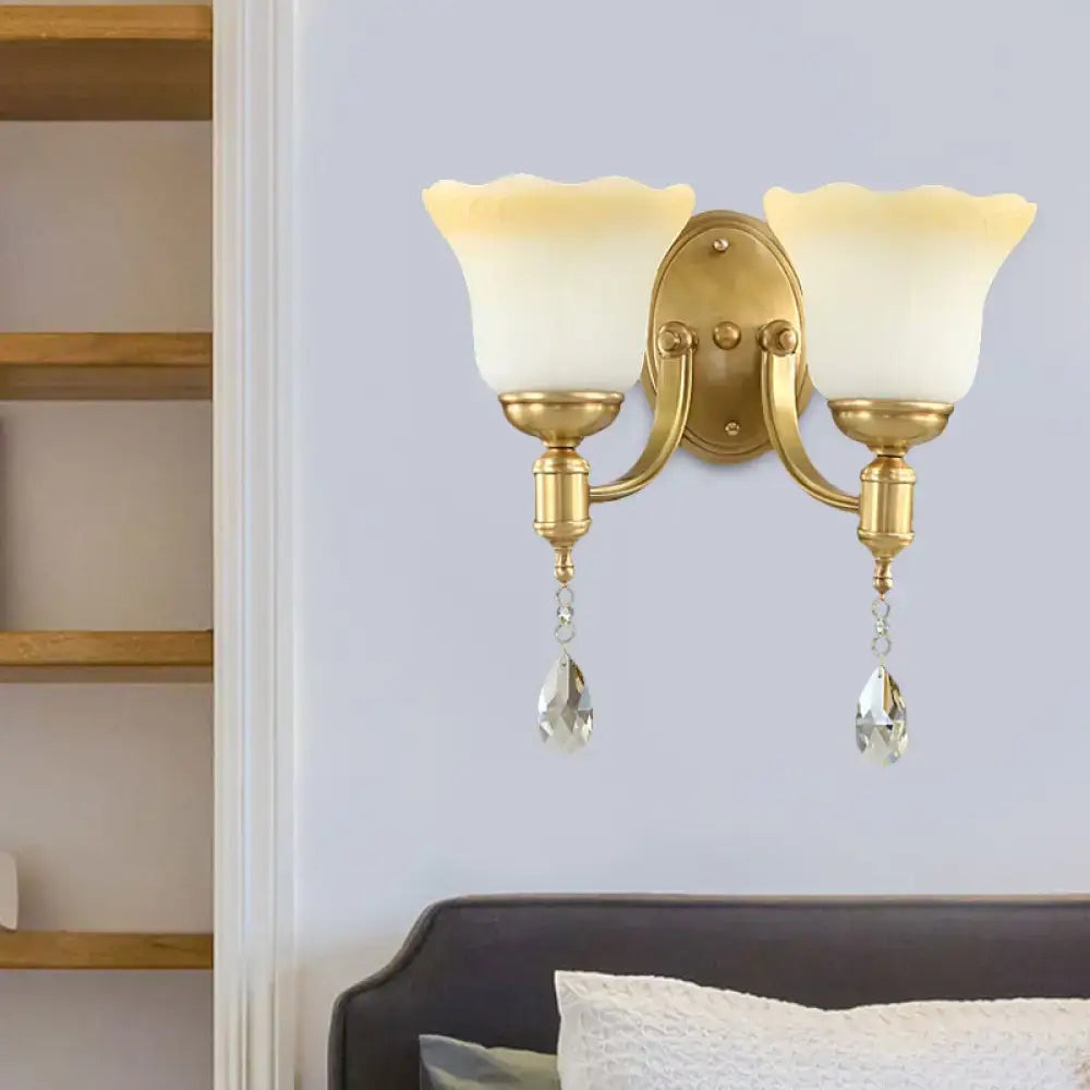 Gold-toned retro wall lamp with two blossom opaque glass shades and crystal teardrops for bedroom sconce lighting