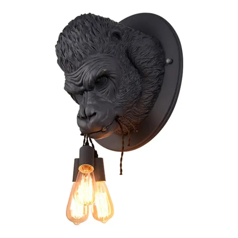 Black gorilla resin wall lamp with two glowing filament bulbs hanging from its mouth for retro bedroom lighting decorbites