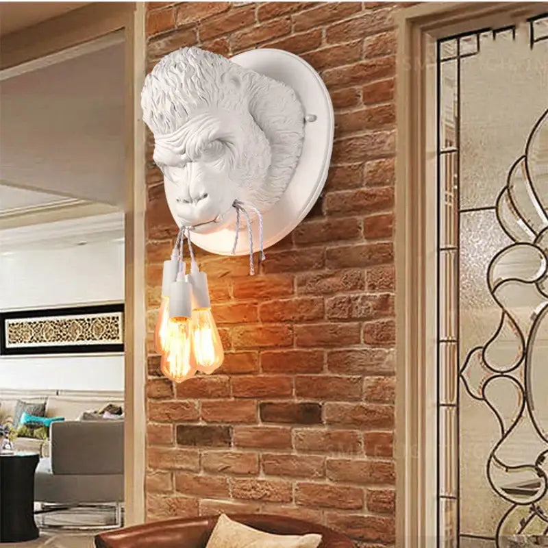 White ceramic decorbites gorilla resin wall lamp with three exposed filament bulbs for bedroom lighting