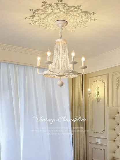 White ornate decorbites crystal chandelier with crystal droplets and candle-style bulbs for dining room decor